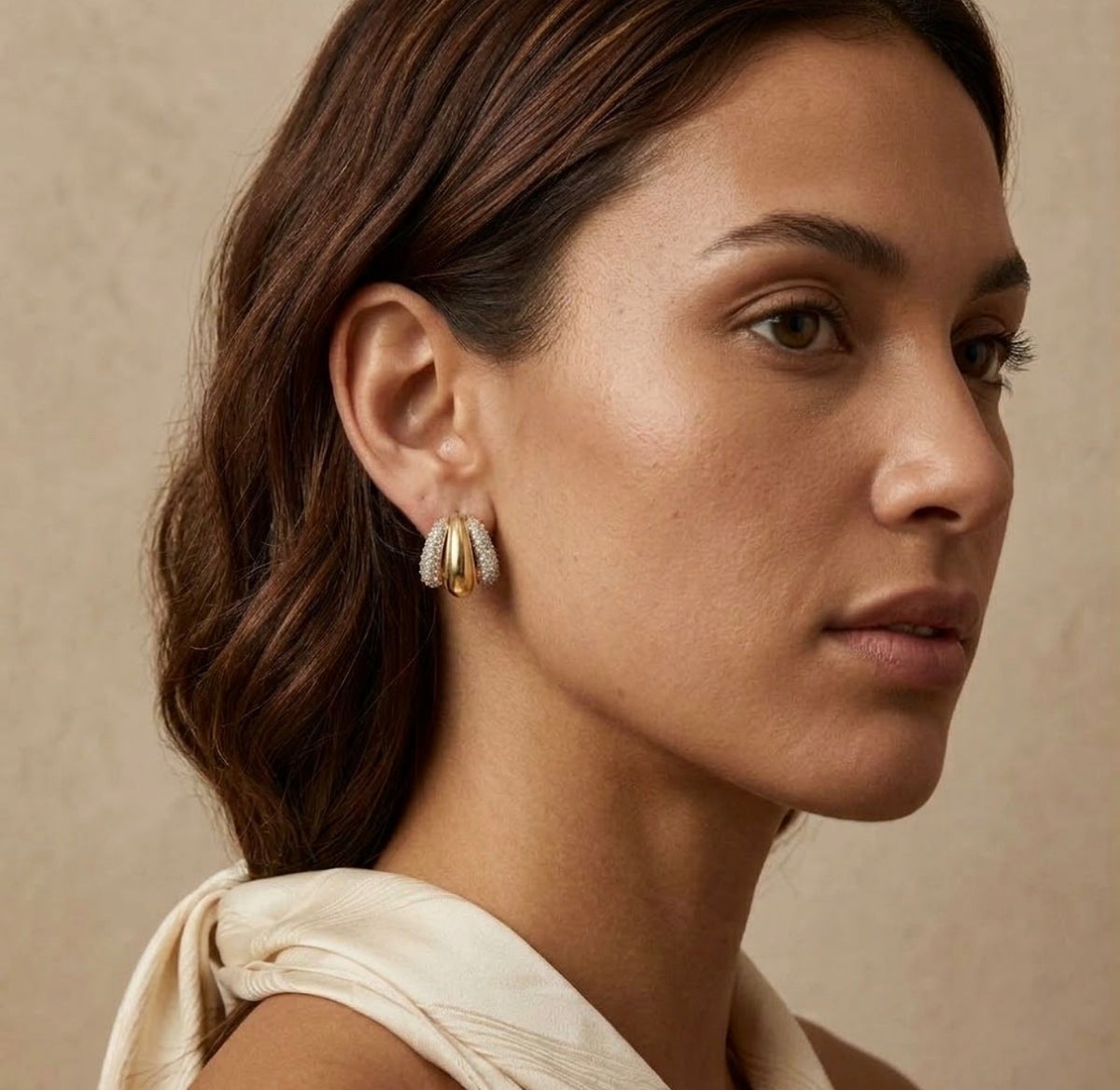 Two-tone gold and diamond pave triple hoop earring model lifestyle on face view.