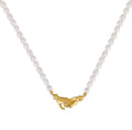 A close-up photograph against a white background shows a pearl necklace with two interlocking, golden human hands as a clasp at the bottom. The hands are molded in intricate detail and meet to form a secure interlocking clasp where the white pearl beads from each side of the necklace chain connect. One hand appears to be gripping the other. Tiny golden beads separate the last pearl on either side of the necklace from the sculpted gold hand.