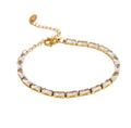Gold baguette cut cubic zirconia tennis bracelet with an adjustable chain on a plain background.